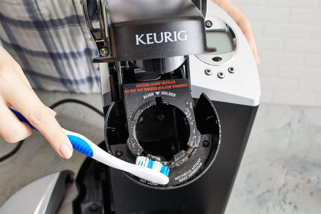 Clean the Keurig k-cup holder with a toothbrush